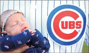  ?? KEVIN E. SCHMIDT/CHICAGO TRIBUNE ?? Holding his 3-week-old daughter Ivy, Phil Young talks about being a life-long Cubs fan outside his Davenport, Iowa home Tuesday.