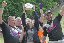  ?? KIN CHEUNG, AP ?? Delaney Irving, centre, won the women’s downhill race during the cheese rolling contest at Cooper’s Hill in Brockworth, Gloucester­shire, England on Monday.