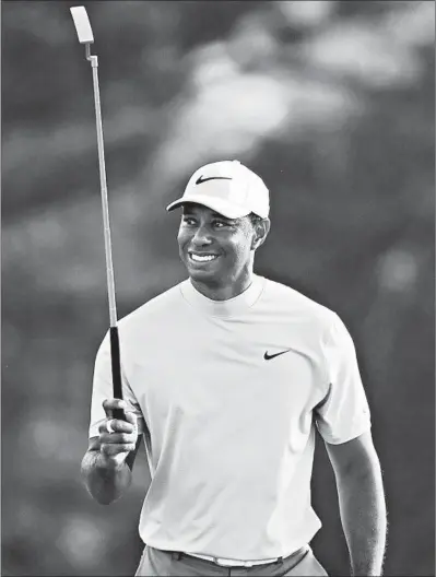  ?? JASON GETZ/ATLANTA JOURNAL-CONSTITUTI­ON ?? Tiger Woods smiles as he walks up to the 18th green in the third round of the Masters on Saturday at Augusta.