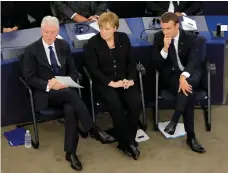  ?? Michel Euler / AP; Odd Andersen / AFP ?? Former US president Bill Clinton, German chancellor Angela Merkel, and French president Emmanuel Macron during the memorial ceremony, left. Mrs Merkel with members of the German parliament at the cathedral, right