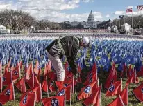  ?? Stephanie Keith / Getty Images ?? A worker adjusts decorative flags on the National Mall that represent the thousands not able to attend the inaugurati­on.