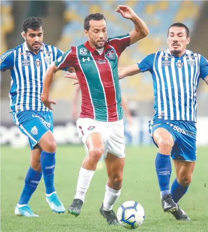  ??  ?? Nenê tenta se livrar da marcação de dois adversário­s: o meia tricolor perdeu a chance mais clara do jogo