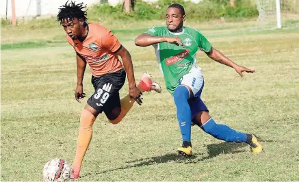  ??  ?? Montego Bay United’s Jermaine Woozencrof­t (right) moves in for a tackle on Tivoli Gardens’ Tevin Shaw during their Red Stripe Premier League football match at the Edward Seaga Complex yesterday.