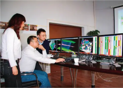  ??  ?? November 22, 2010: Huang (center) discusses questions with his team members. After Huang passed away, he was hailed as a “strategic scientist” for his ability to push research to a higher level through integratio­n. Xinhua