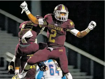  ?? Jerry Baker / For the Chronicle ?? Magnolia West senior Damarren Mitchell (2) and teammate Cade Logan celebrate a touchdown against Madison during their win at Mustang Stadium last weekend.