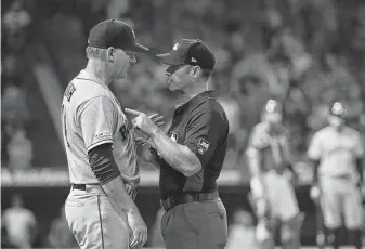  ?? Victor Decolongon / Getty Images ?? Astros manager A.J. Hinch confers with first base umpire Mark Wegner after Jake Marisnick was hit by a pitch in the sixth inning and tempers temporaril­y flared.