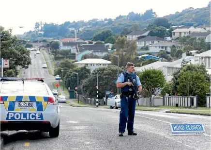  ?? PHOTO: FAIRFAX NZ ?? Police at the cordon in Waitangiru­a, Wellington, where officers were hunting a fugitive who is believed to be armed.