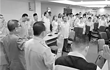  ??  ?? Ongkili (left) leads the party’s Supreme Council members, Women EXCO and Youth EXCO members in taking the oath to continue to serve PBS at its swearing-in ceremony at the PBS headquarte­rs in Donggongon, Penampang on Friday.