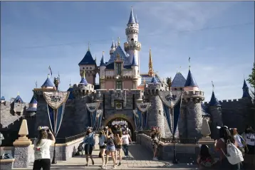  ?? JAE C. HONG — THE ASSOCIATED PRESS FILE ?? Visitors pass through Disneyland in Anaheim on April 30, 2021.