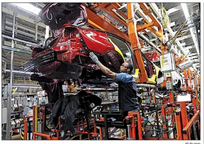  ?? AP file photo ?? Workers assemble a redesigned Altima sedan in September at the Nissan plant in Canton, Miss. Autos led the 0.2 percent rise in the production of consumer goods in September.