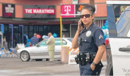  ?? FREDERIC J. BROWN/AFP/GETTY IMAGES ?? Police monitor a roadblock Tuesday in front of the late Nipsey Hussle’s The Marathon Store in Los Angeles, where the rapper was killed.