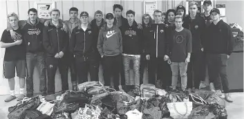  ?? HOLLY ARMSTRONG ?? Members of the Prairie Storm Extreme Hockey midget AA team pose with bags that are full of gifts for less-fortunate members of the community. The gifts are to be distribute­d in Regina on Sunday.