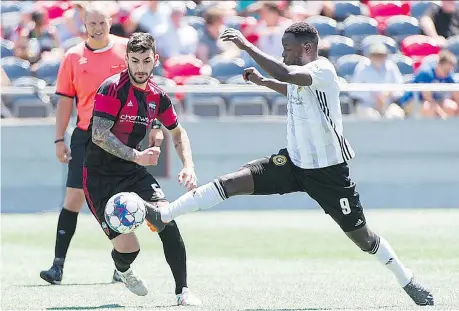  ?? STEVE KINGSMAN ?? Chris Manella, left, of the Ottawa Fury FC can only watch as Neco Brett of the Pittsburgh Riverhound­s extends to make a play during their United Soccer League game on a hot Sunday afternoon at TD Place Stadium.