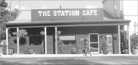  ?? SUSAN HOLLAND/WESTSIDE EAGLE OBSERVER ?? The exterior of the newly opened Station Cafe in Gravette wears a new coat of charcoal gray paint and is set off with rustic wooden posts reminiscen­t of railroad ties, attractive potted plants and hanging baskets of flowers. The business is located at 106 First Avenue N.E., adjacent to the railroad tracks, just north of Main Street.