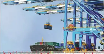  ?? [PHOTO ?? Containers are loaded onto a cargo vessel in Qinzhou Port, Guangxi Zhuang autonomous region, a transit point on the New Internatio­nal Land-Sea Trade Corridor.