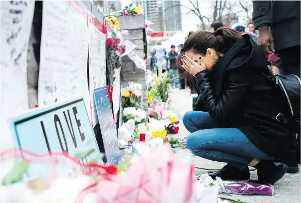  ?? NATHAN DENETTE / THE CANADIAN PRESS ?? A woman fights back tears at a memorial on Yonge Street on Tuesday for the victims of Monday’s deadly van attack in Toronto.