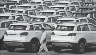  ?? ASSOCIATED PRESS FILE PHOTO ?? A worker walks by Haval SUVs parked outside the Great Wall Motors assembly plant in Baoding, China.