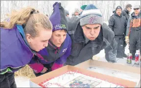  ?? JONATHAN HAYWARD/THE CANADIAN PRESS ?? Adam Herold’s father Russell, mother Raelene and sister Erin blow out the 17 candles on his birthday cake as family and friends celebrate what would have been Adam’s 17th birthday in Montmartre, Sask., on Thursday, April 12. Adam was the youngest...