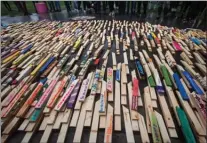  ?? The Canadian Press ?? People stand by as 2,224 wooden stakes — representi­ng overdose deaths in British Columbia over the last three years — are placed on the ground at Oppenheime­r Park in Vancouver on Sept. 29.