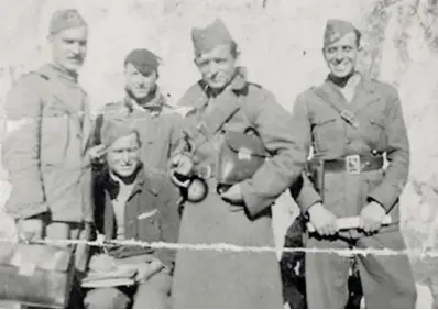  ?? G. G. B. ?? Francisco Buj, sentado, y Andrés Barrero, de pie, con la cartera bajo el brazo, junto a otros compañeros de la Brigada 109, en una imagen de Fernando Barrero Arzac. A la izquierda, la máquina de escribir de Octavio Gonzálvez.