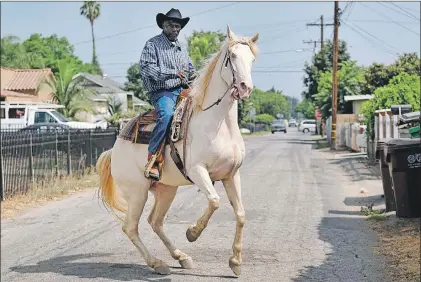  ?? AP PHOTO/RICHARD VOGEL ?? Ivory McCloud manoeuvers his horse, Diamond, down a street in Compton, Calif., on Aug. 7.