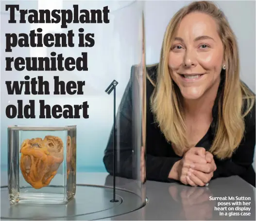  ?? ?? Surreal: Ms Sutton poses with her heart on display in a glass case