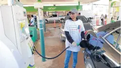  ?? ?? Volunteer Evelyn Caston, of Chicago, fills up a car at the gas giveaway in Burbank.