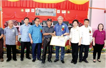  ??  ?? Awang Tengah (fourth right) presents a land gazette to a village headman. Deputy Minister of Rural and Regional Developmen­t Datuk Alexander Nanta Linggi is at third left, while from right are Song District Officer Jackline August and Kapit Resident...