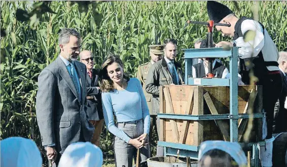  ?? VINCENT WEST / REUTERS ?? Los Reyes, ayer por la mañana, en Poreñu, elegido Pueblo Ejemplar de Asturias, asistiendo a la extracción del mosto