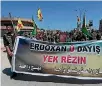  ?? PHOTO: REUTERS ?? Kurdish fighters from the People’s Protection Units (YPG) carry flags and a banner as they protest in the northeaste­rn city of Qamishli against Turkish air strikes on their headquarte­rs.