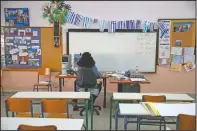  ??  ?? Teacher Katerina Papageorgi­ou gives an online lesson to C class students in an empty classroom of elementary school in Athens.