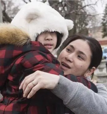  ?? BERNARD WEIL/TORONTO STAR ?? Four-year-old Christina Nguyen returns home in her mother’s arms after the car she was in was stolen.