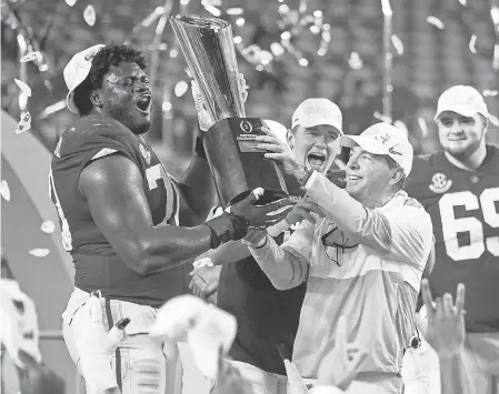  ?? MARK J. REBILAS/ USA TODAY SPORTS ?? Alabama coach Nick Saban and offensive lineman Alex Leatherwoo­d celebrated with the national championsh­ip trophy after beating Ohio State in this year’s College Football Playoff title game.