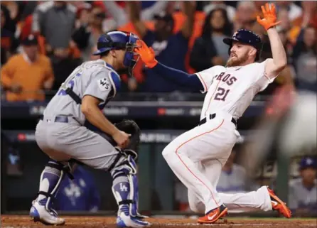  ?? CHRISTIAN PETERSEN, GETTY IMAGES ?? Astros’ Derek Fisher slides into home score the game-winning run in the 10th inning, ending a five-hour thriller in Houston on Sunday.