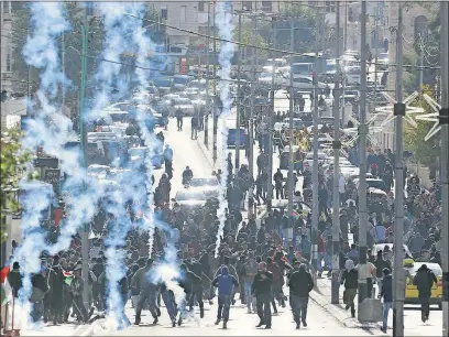  ?? [NASSER SHIYOUKHI/THE ASSOCIATED PRESS] ?? Israeli troops fire tear gas toward Palestinia­ns in the West Bank city of Bethlehem on Thursday during a protest against U. S. President Donald Trump’s decision to recognize Jerusalem as the capital of Israel.