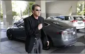  ?? RICH PEDRONCELL­I — THE ASSOCIATED PRESS FILE ?? Then-Texas Gov. Rick Perry walks over to talk to reporters after driving up in a Tesla Motors Type S electric car in Sacramento on June 10, 2014. Perry arrived at a meeting with statewide GOP lawmakers and officials across the street from the state Capitol to try to persuade California­based Tesla to build a plant in Texas.