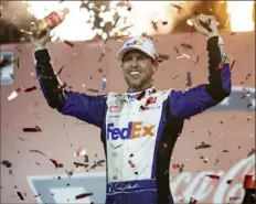  ?? Associated Press ?? Denny Hamlin celebrates in Victory Lane after defeating Joe Gibbs Racing teammate Kyle Busch in double overtime.