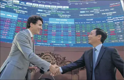 ?? CP PHOTO ?? CEO Ho Chi Minh Stock Exchange Nguyen Vu Quang Trung shakes hands with Canadian Prime Minister Justin Trudeau after he symbolical­ly rang the gong at the Ho Chi Minh City Stock Exchange in Ho Chi Minh, Vietnam Thursday.
