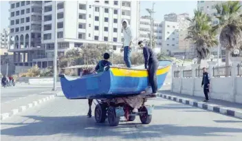  ?? Reuters ?? Palestinia­ns transport a fishing boat on a horse cart after being repaired at the seaport in Gaza City on Wednesday. —