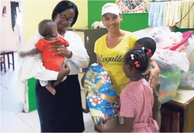  ?? CONTRIBUTE­D ?? SPREADING THE LOVE: Human resources director at Royalton White Sands, Angeline Anderson (left), and community relations manager at the resort, Debbie Bailey, interact with children at the Blossom Gardens Child Care Facility in Montego Bay during a...