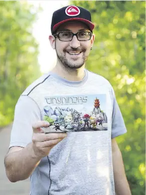  ??  ?? Ryan Leininger holds a copy of his two-player board game Tiny Ninjas, which was successful­ly funded on the crowdfundi­ng site Kickstarte­r.