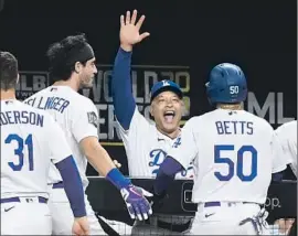  ?? Wally Skalij Los Angeles Times ?? AN EXUBERANT Dave Roberts celebrates with Mookie Betts, who scored the go- ahead run in the sixth inning against the Rays in Game 6. Roberts says this season was more diff icult than other seasons.