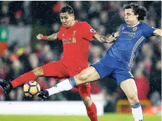  ?? AP ?? Chelsea’s David Luiz (right) competes for the ball with Liverpool’s Roberto Firmino during the English Premier League match between Liverpool and Chelsea at Anfield stadium in Liverpool, England, yesterday. The game ended 1-1.