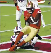 ?? CHRISTIAN PETERSEN — GETTY IMAGES ?? Receiver Brandon Aiyuk scores the first touchdown Monday for the 49ers ahead of Bills cornerback Levi Wallace.
