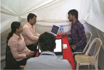  ??  ?? A job seeker is interviewe­d by human resource managers at a job fair in Chinchwad, India. — Reuters photo