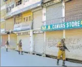  ?? WASEEM ANDRABI/ HT PHOTO ?? Paramilita­ry soldiers stand guard near a closed market as separatist­s announce a twoday lockdown in the Valley over Article 35A, in Srinagar on Thursday.