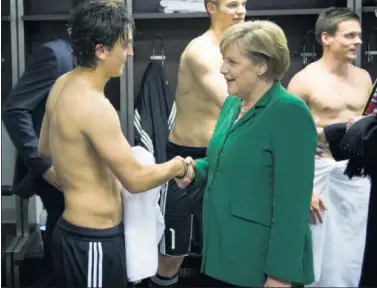  ??  ?? BUROCRACIA. Angela Merkel saluda a Özil en el vestuario de la selección alemana.