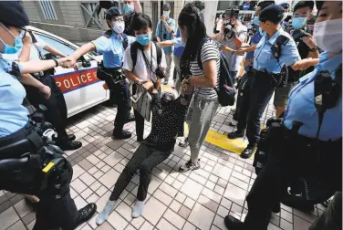  ?? Peter Parks / AFP / Getty Images ?? Police officers drag activist Alexandra Wong, also known as Grandma Wong, away from the courthouse in Hong Kong, where executives from the city’s prodemocra­cy Apple Daily newspaper were denied bail.