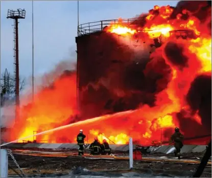  ?? AFP ?? A photograph issued by the Ukrainian State Emergency Service shows firefighte­rs putting out a fire at a fuel storage depot in the western city of Lviv after Russian missile strikes on March 26. The West is pushing Arab nations to raise oil production to contain soaring prices spurred by the conflict.
