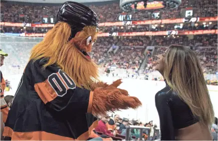  ??  ?? Gritty dances with a Flyers dancer during a home game this month against the Devils.